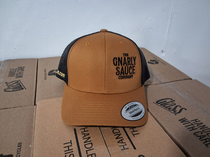 Brown and black cap with 'The Gnarly Sauce Company' logo in black on cardboard boxes.